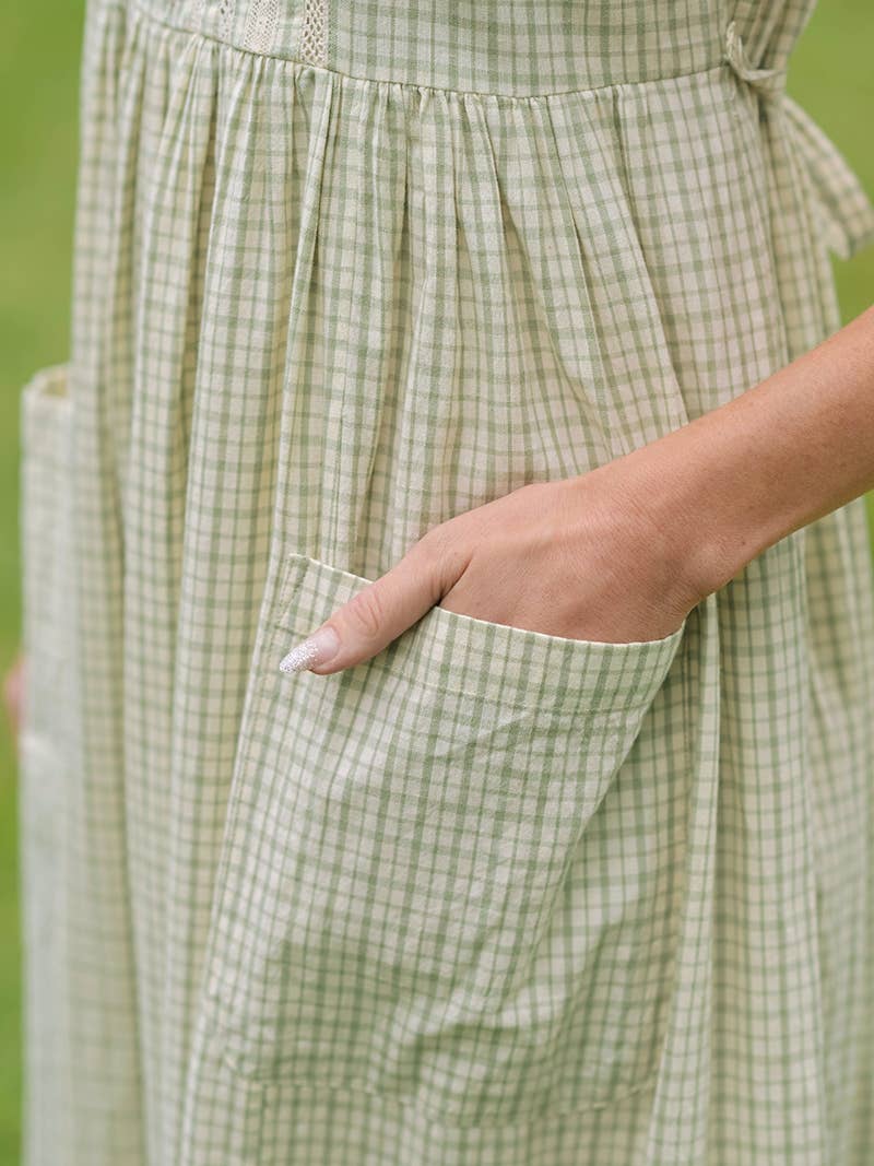 Green checkered dress with a pocket on a blurred green background