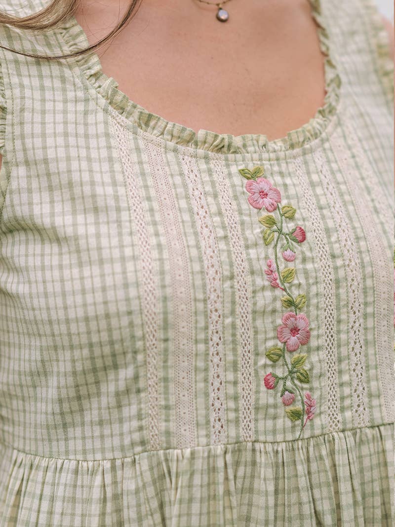 Green checkered dress with floral embroidery on a plain background