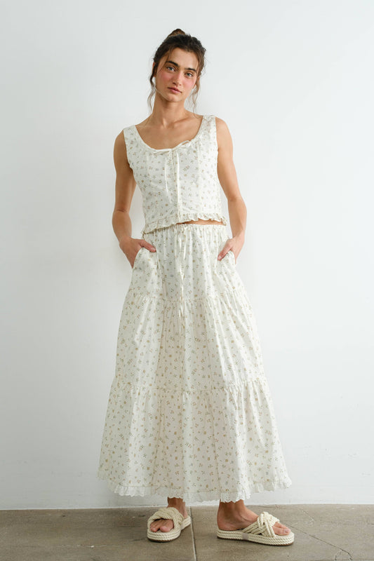 Woman wearing a white floral dress against a plain background
