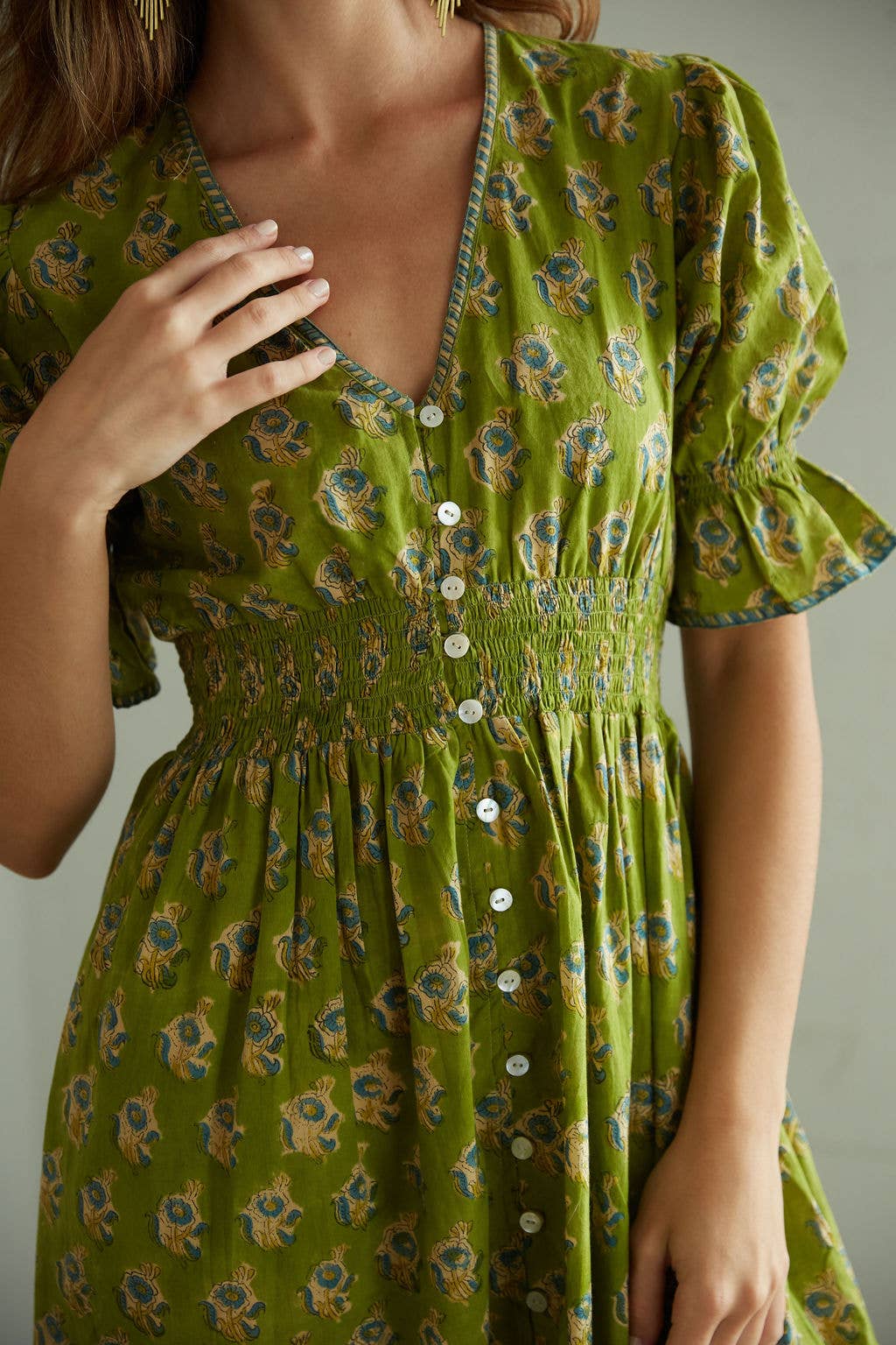 Green floral dress worn by a person, with a neutral background